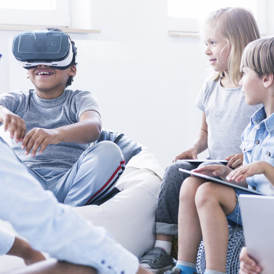 Kids with their teacher trying virtual reality and learning