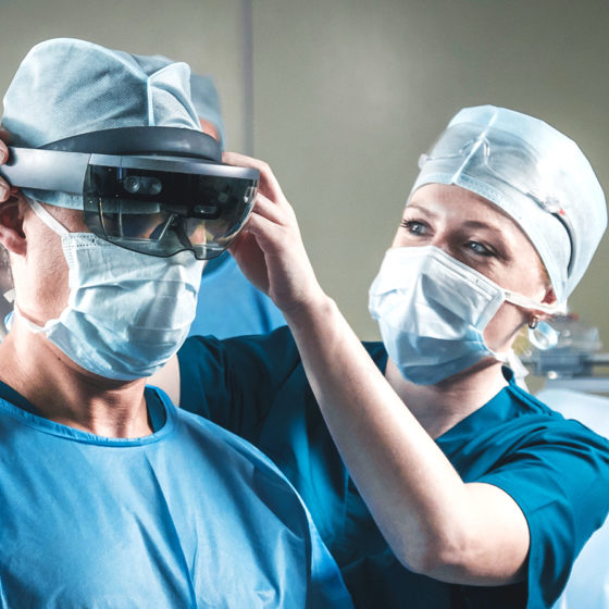 a nurse helping surgeon to wear hololens in operating room