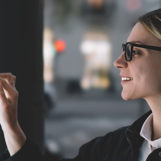 smiling female touching kiosk screen unaware of germs